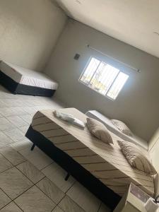 a bedroom with two beds and a window at Hotel São Mateus in São Paulo +6 photos