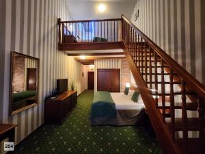 a bedroom with a bed and a stair case at City Hotel Morris in Česká Lípa