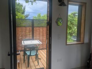 a door leading to a balcony with a table and chair at Gîte Le Pic Epeiche in Saint-Roman