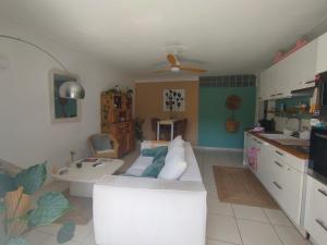 a living room with a white couch and a kitchen at Chaleureux appartement in Nîmes +4 photos