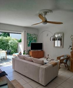 a living room with a couch and a ceiling fan at Chaleureux appartement in Nîmes