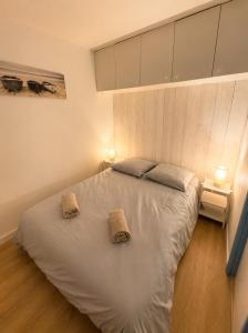 a bedroom with a bed with two towels on it at Le Marin in Hossegor +4 photos