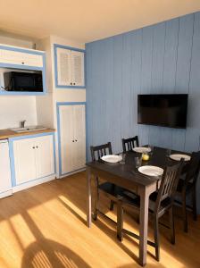 a dining room with a table and chairs and a kitchen at Le Marin in Hossegor