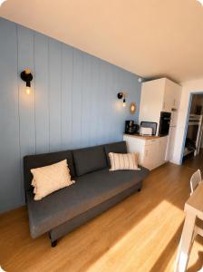 a living room with a couch and a kitchen at Le Marin in Hossegor