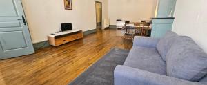 a living room with a couch and a wooden floor at Private Apartment in Rochechouart
