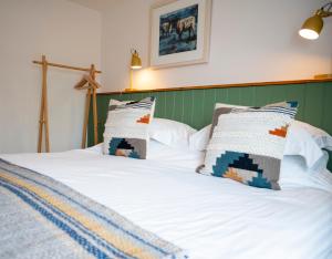 a bed with two pillows on top of it at Squirrel Away Apartments in Crieff