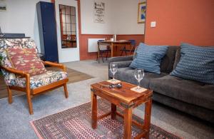 a living room with a couch and a table with wine glasses at Squirrel Away Apartments in Crieff