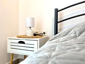 a bed with a nightstand with a lamp on it at Andreana's Place Rhodes in Asgourou +24 photos