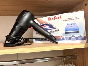 a black hair dryer on a shelf next to a box at Andreana's Place Rhodes in Asgourou