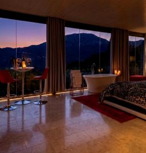 a bedroom with a bed and a tub and large windows at DDG Retreat in Casares