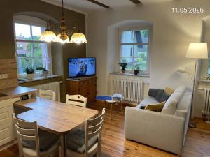 a living room with a table and a couch at Ferienwohnung "Altes Schloss Wilhelmsfeld" in Eselsberg