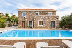 a villa with a swimming pool in front of a house at PETRINO Hotel in Mythimna