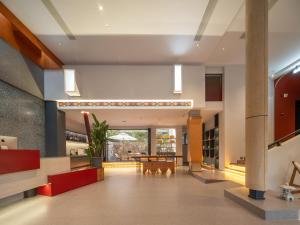 a lobby of a hotel with a table and chairs at Zhangjiajie Utopia Hotel-New Hotel,English Speaking Host,Free Shuttle Service to East Gate of forest park,Free Fresh Coffee&Tea,Free Self-Service Laundry & Drying, Super-Large Swimming Pool,Tourism Service, Family and Group-friendly in Zhangjiajie