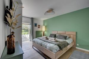 a bedroom with a bed and a vase on a table at Maison de Charme avec Spa Privatif & Jardin en Pleine Nature - Plages à moins de 20min in Guerlesquin