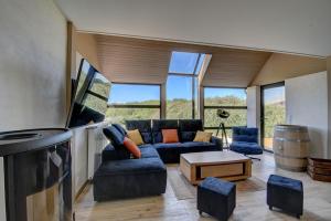 a living room with a couch and a table at Maison de Charme avec Spa Privatif & Jardin en Pleine Nature - Plages à moins de 20min in Guerlesquin