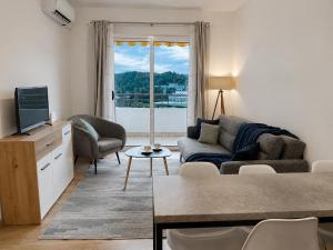 a living room with a couch and a tv at Comfort Apartment Becici in Bečići