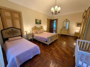 a bedroom with two beds and a chandelier at Cascinotto Stella Silvia in Piossasco