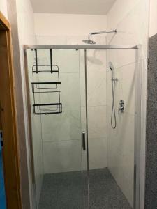 a shower stall with a glass door with a shower at pokoje do wynajęcia in Grajewo