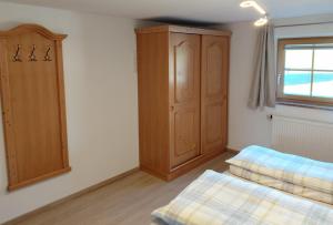 a bedroom with a wooden cabinet and a bed at Ferienwohnung Kollerlehen in Bischofswiesen +3 photos