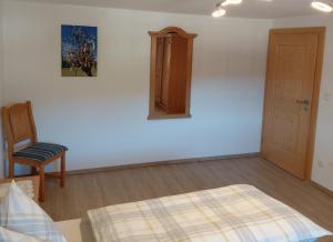 a bedroom with a bed and a chair and a mirror at Ferienwohnung Kollerlehen in Bischofswiesen