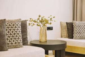 a vase with flowers on a table in a room at Minares Luxury Suite in Rethymno