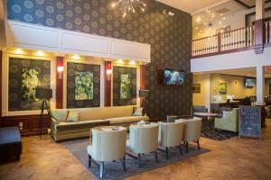 a lobby with a couch and tables and chairs at Parke Regency Hotel & Conference Center in Bloomington