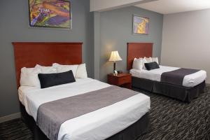 a hotel room with two beds and a lamp at Parke Regency Hotel & Conference Center in Bloomington