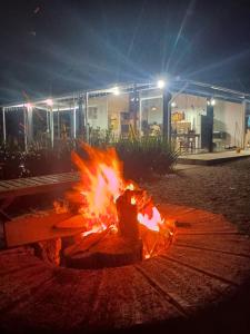 a fire burns in front of a building at night at La casa de vidro in Tijucas +13 photos
