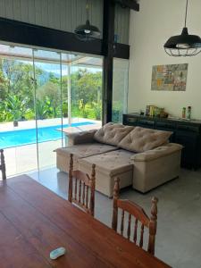 a living room with a couch and a table at La casa de vidro in Tijucas