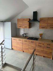 a kitchen with wooden cabinets and a white refrigerator at pokoje do wynajęcia in Grajewo