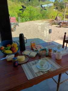 a table with food and a bowl of fruit on it at La casa de vidro in Tijucas