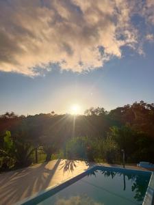 a view of the sunset from a swimming pool at La casa de vidro in Tijucas