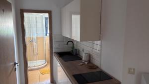 a small bathroom with a sink and a shower at Apartments & rooms Ana Sukosan in Sukošan +51 photos