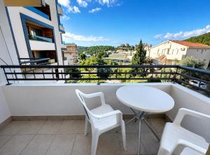 a white table and chairs on a balcony with a view at Comfort Apartment Becici in Bečići +3 photos