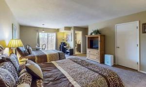 a hotel room with two beds and a television at The Safari Lodge in Osage Beach