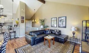 a living room with a leather couch and a table at The Safari Lodge in Osage Beach +51 photos