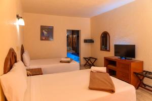a hotel room with two beds and a television at Eurohotel in Ciudad del Carmen