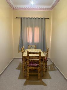 a table and chairs in a room with a curtain at Comfortable Luxury House in Merzouga +8 photos
