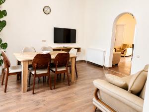 a dining room with a table and chairs and a tv at Green Garden in Batumi