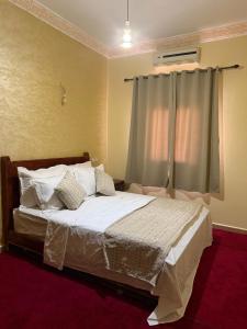a bedroom with a bed with white sheets and pillows at Comfortable Luxury House in Merzouga