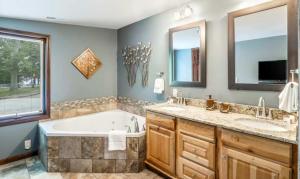 a bathroom with two sinks and a tub and a large window at Unforgettable Lake Memories in Lake Ozark