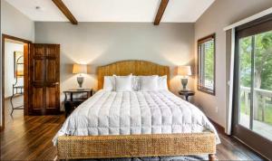 a bedroom with a large bed and two windows at Unforgettable Lake Memories in Lake Ozark