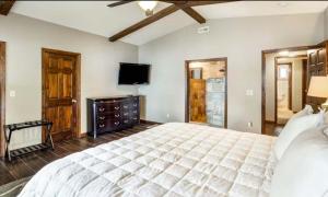 a bedroom with a large bed and a flat screen tv at Unforgettable Lake Memories in Lake Ozark +19 photos