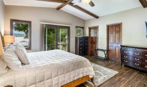 a bedroom with a bed and a dresser and windows at Unforgettable Lake Memories in Lake Ozark
