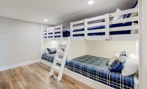 two bunk beds in a white room with wood floors at Lake Ozarks in Rocky Mount