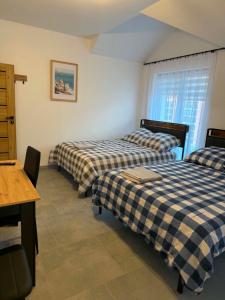 a bedroom with two beds and a table and a window at pokoje do wynajęcia in Grajewo