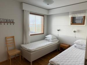 two beds in a small room with a window at Ruka Center Chalet 3B4 - Ski-In Ski-Out - All services nearby - AC - Fireplace - Wifi - Own parking place in Ruka
