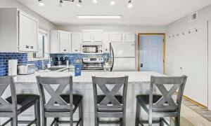 a kitchen with a counter with four chairs around it at Full Moon Condo in Lake Ozark