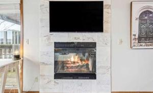 a living room with a fireplace with a tv on a wall at Full Moon Condo in Lake Ozark