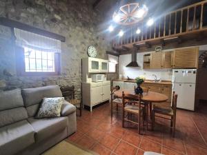 a living room with a couch and a table and a kitchen at La Cochera del Abuelo in Medina de Pomar